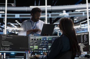 Veri merkezindeki bilgisayar bilimcisi PC kullanarak birbirine bağlı düğümlerden oluşan yapay zeka sinirsel ağlarını görselleştiriyor. Sunucu çiftliği çalışanı AI sistemlerinin işleme bilgisini denetliyor