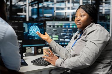 Sunucu odası mühendisliği ekibi beyin fırtınası yapıyor. Kesintileri azaltmak için yapay zeka kullanıyorlar. Veri merkezi ekipmanları için AI güdümlü çözümler tasarlayan ve uygulayan takım arkadaşları