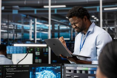 Veri merkezindeki kızgın mühendis, yapay zeka bilgisayarlı model kullanırken ekipmanları etkileyen hatalardan rahatsız oluyor. Sinirli sunucu odası çalışanı bozuk yapay zeka öğrenme algoritmaları yüzünden hayal kırıklığına uğradı