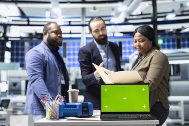 Danışmanlar ve fabrika analistleri, güneş paneli fabrikasında her detayı temiz enerji verimliliği ve güneş teknolojisi yeniliğiyle aynı hizaya getirmek için bir kopya ekran üzerinde çalışıyorlar..