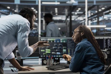 Veri merkezi yazılım geliştiricileri makine öğrenme eğitimi için kullanılan programlama ekipmanları. Sunucu odası bilişim uzmanları konuşuyor, yapay zeka sistemlerini güncellemek için bilgisayar üzerinde kod çalıştırıyorlar