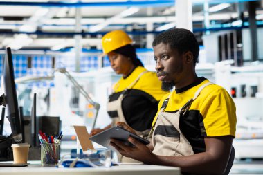 Güneş paneli teknisyeni tablet üzerinde alternatif enerji sistemleri için CAD modelleri ve teknik çizimler tasarlıyor. İnsan mühendisi, verimlilik ve yenilik için fotovoltaik tasarımı güvence altına aldı.