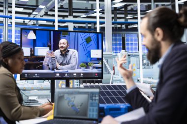 Fabrika uzmanları uzaktan telekonferansta CAD programında üretim tesisleri dizayn ediyorlar. İşçiler çevrimiçi video çağrı toplantısında fabrika üretim planlarını optimize etmek için simülasyon yazılımı kullanıyorlar