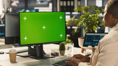 Çalışan proje görevlerini tamamlamak için izole ekran PC görüntüsünü kullanıyor. Afrika kökenli Amerikalı ofis çalışanı, bilgisayar monitörü ve kamera A 'nın veri istatistiklerini okuyor.