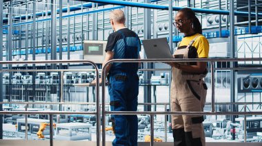 Akıllı fabrika mühendisi tesis zeminindeki robotik silah ve taşıma sistemlerini denetliyor. Endüstri 4.0 fabrika teknisyeni sistem performansını izliyor ve sorun giderme sorunları, kamera A