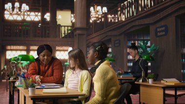 Kütüphanede öğretmenlerinin yanında beşlik çakan tatmin olmuş genç öğrenciler okul konularındaki ilerlemelerinden memnunlar. Profesör, özel derslerde akademisyenleriyle gurur duyuyor. Kamera A.