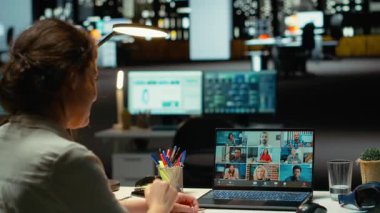 Yetkili yönetici, Webinar video görüşmesinde brifing veriyor. Ofiste saatler sonra son rapor verilerini paylaşıyor. Gece yarısı web konferansında ortak toplantı. Kamera B.