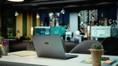 Geceleri boş bir iş bürosunda veri raporları ve analizler, gece yarısı parıltısı ve şirket yönetim kurulunda ışıklar sergileniyor. Yönetim için finansal tahminleri olan modern çalışma alanı.