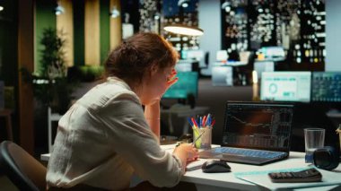 Hisse senedi ticaret başarısızlığı ve para kaybı yüzünden hayal kırıklığına uğrayan kadın çalışanlar, fiyat düşüşü ve iflas veya mali krizden endişelenen düşüşü izliyor. Gece vakti. Kamera A.