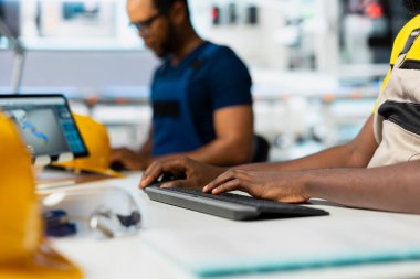 Güneş enerjisi mühendisi, araştırma ve yenilik odaklı çevre dostu fabrikada tasarım modellerini güncelliyor. Erkek teknisyen dijital sistemler kullanarak sürdürülebilir endüstriyel büyümeyi destekliyor.