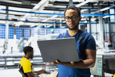 Siyahi denetçi güneş paneli üretiminde güç optimizasyonu geliştiriyor, fotovoltaik sistemler için sürdürülebilir yenilenebilir enerjiyi artırmak için dizüstü bilgisayar üzerinde çalışıyor. Çevre dostu tesis.