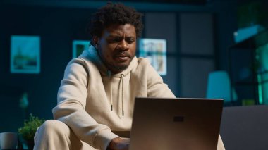 Günümüz oturma odasında otururken dizüstü bilgisayarındaki programları ve notları yöneten genç bir erkek serbest yazar. Etkileyici bir adam verimli bir tele çalışma seansı için bilgisayara bakar. Kamera A.