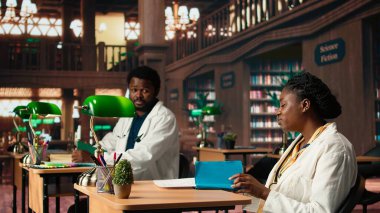 Afro-Amerikan tıp fakültesi kütüphanedeki özel kitaplardan ders alıyor, tıbbi araştırmalarını yapıyor ve sağlık yöntemlerini öğreniyor. Kariyeri için çok çalışan bir kadın. Kamera A.