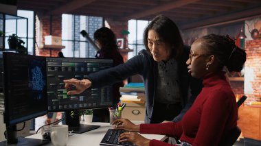 Yapay zeka bürosundaki adam yazılım mühendisinin makine öğrenimini denetleme pozisyonunda. Yapay Zeka Teknoloji Girişim Yöneticisi çalışanların kod hatalarını düzeltmesine yardım ediyor, Kamera A