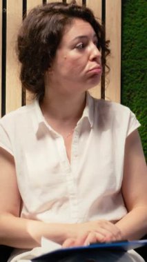 Dikey video, iş başvurusunda bulunan kadının koridorda gergin ve titriyor sırada bekliyor ve iş bulma endişesi ve baskısı yüzünden sabırsızlanıyor. Koridorda sıra olun.