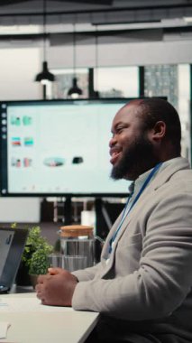 İş bulma süreci tartışmaları sırasında insan kaynakları ekibinin karşısında oturan Dikey Video Siyah iş arayıcısı, iş tecrübesi ve iş organizasyonu iş teklifi nitelikleri sunuyor. Kariyer