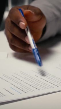 Bir şirket iş görüşmesinde CV belge değerlendirmesinin dikey görüntüsü. İş kadını, Afrika kökenli Amerikalı adaylara geçmiş çalışma deneyimi ve kağıt üzerinde gösterilen çalışmalarına dayanarak sorular soruyor.