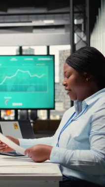 Röportaj sırasında insan kaynakları yöneticisiyle karşı karşıya oturan dikey video Afrikalı Amerikalı iş arayıcısı, özgeçmiş sunuyor ve yeni bir iş ilanı, potansiyel ve kariyer hedeflerini tartışıyor