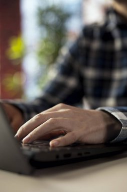 Ofisteki serbest çalışan biri, internette internete göz atıyor, internette bilgi araştırıyor. Laptop klavyesinde yazan telesekreteri kapat, çalışma görevleriyle ilgili verileri bulmak için arama motoru kullan