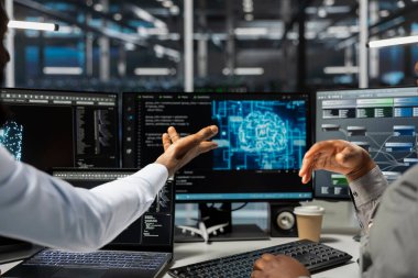 Veri merkezi teknisyenleri beyin fırtınası yapıyor, ofiste birlikte çalışıyorlar, yapay zeka bilgisayarlı model kullanıyorlar. Yapay zeka öğrenme algoritmalarıyla çalışan sunucu odası iş arkadaşları