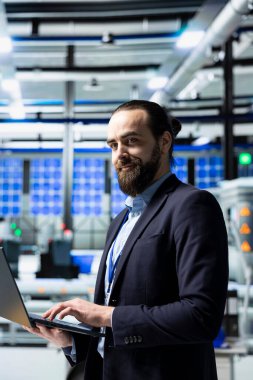 Şirket kostümlü yönetici, yeşil enerji endüstrisindeki modern altyapı ve liderliği sembolize eden bir güneş paneli fabrikasında teftiş yapıyor. Üretim planlama ve teknoloji.