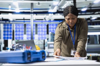 Kadın usta mühendis güneş enerjisi üretimi üzerinde kalite kontrolü yaparak, altyapı geliştirme ile daha ucuz yenilenebilir enerji sergiliyor. Güneş santralinde endüstri mühendisliği.