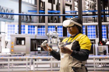 Sanayi elektrik santrali teknisyeni VR kulaklık takıyor ve kontrolörleri eğitime katılıyor. Akıllı fabrika çalışanı imalat işlemlerinde sanal gerçekliği kullanıyor.