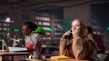 Yüksek sesle konuşarak öğrencileri kütüphanede rahatsız eden gürültücü kız çalışma alanında kabalaşıyor ve telefonuna cevap veriyor. Rahatsız edici rahatsız edici kişi sessiz kalmasını istedi. Kamera A.