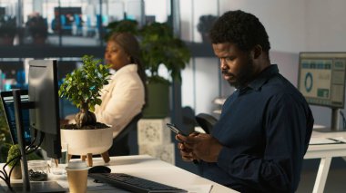 Bilgisayara veri girdikten sonra arkadaşlarına mesaj atmak için cep telefonu kullanan bir muhasebeci. İşyerinde çalışan akıllı telefondan yazı yazarken bilgisayar ve kamera A 'daki görevleri tamamlıyor.