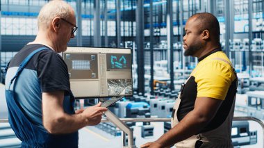 Akıllı fotovoltaik fabrikası uzmanı dizüstü bilgisayardaki sistem performans ölçümlerine bakıyor. Afrika-Amerika güneş panelleri fabrika işçisi IoT sensörleri ve kamera A aracılığıyla enerji üretimini takip ediyor.