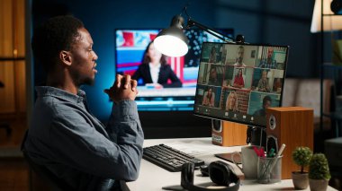 Afrika kökenli Amerikalı bir adam ve yardımcıları çatı katında sanal bir toplantıya katılıyor, bir video konferansı aracılığıyla tartışıyor ve iletişim kuruyorlar, evde uzaktan kumanda yapıyorlar. Kamera B.