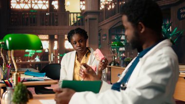 Afrikalı Amerikalı dişçilik öğrencileri yaklaşan sınavlar için dişleri inceliyor, kütüphanede çene modeli kullanarak doğum kontrol seansı öğreniyor. Oral sağlık eğitimine adanmışlık. Kamera A.