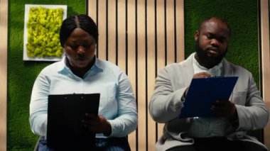 İş görüşmesi ve açık pozisyon için kayıt formlarını dolduran Afrikalı Amerikalı başvuru sahipleri başarılı bir işe alım ve İK ile görüşme sağlıyorlar. Vasıflarını yazıyorum. Kamera B.