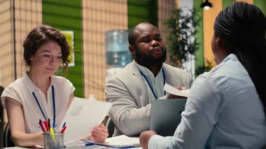 CV belgesini gözden geçirmek için bir başvuru sahibi ile görüşen çeşitli İK mülakatçıları, yetenek edinme, iş deneyimi ve girişim bindirme sürecinin nitelikleri üzerinde duruluyor. Kamera B.