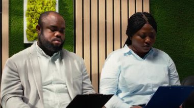 Bayan sekreter, koridordaki iş başvurularına belgelerini ve özgeçmişlerini veriyor, önemli bilgileri dolduruyor ve kariyer fırsatı için hazırlanıyor. İşyeri desteği. Kamera B.