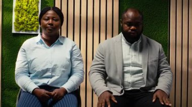 Koridordaki adaylar, İK sekreterinden tramvaylı formlar alıyor, işe alım sürecine katılıyor ve iş görüşmesi detaylarını doldurmak için sırada bekliyorlar. İşyeri desteği. Kamera B.