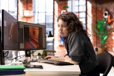 Kadın geliştirici, bilgisayar üzerinde sanal yapay zeka asistanı ile bir oyun merkezi tasarlamak için etkileşime girer, bir bilim kurgu video oyunu için geleceksel uzay istasyonu tasarımları oluşturmak için otomasyon ve makine öğrenme kullanır..