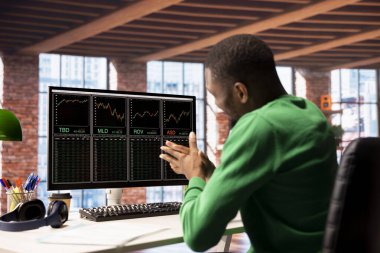 Borsa simsarı, hisse senedi satıp kârını maksimuma çıkararak para kazandıktan sonra heyecan içinde elini ovuşturuyor. Hisse senedi alım satımından kazanılan mali kazancı kutlayan çok mutlu bir adam.