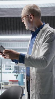 Modern laboratuvarda örnekleri analiz eden profesyonel bilim adamının dikey video portresi, tıbbi keşif süreci biyoteknoloji araştırmaları ve moleküler bilimi içerir. Sağlık hizmetleri veri yeniliği