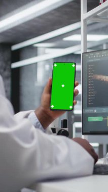 Akıllı telefonda laboratuvar çalışması için krom anahtar ekranı kullanan dikey video uzmanı moleküler bilim için deney verileri üzerinde çalışıyor. Gelişmiş araştırma, farmakoloji ve biyoteknoloji keşfi