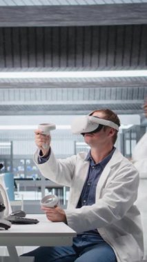 Laboratuvarda VR kulaklık kullanarak biyokimya ve nanoteknolojinin 3 boyutlu etkileşimli simülasyonlarını inceleyen dikey video araştırmacısı. Gadget, bilimde yenilik ve tıp alanında ileri düzeyde araştırma gösteriyor