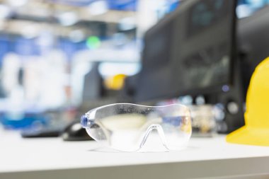 Güneş enerjisiyle çalışan bir tesiste güvenlik gözlüklü boş bir yüksek teknoloji masası. Üretim sürecini garantiliyor. Sürdürülebilir çözümler için güneş enerjisi otomasyonu, yenilenebilir enerji. Kapat..