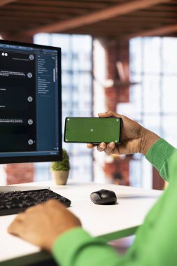 Yapay zeka sohbet robotuyla görevlerin nasıl çözüleceğini öğrenmek için krom tuşlu akıllı telefondan ders izleyen bir adam. LLM asistanları hakkında izole edilmiş cep telefonundaki video rehberlerine bakan kişiyi kapat