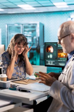 Klinikte ağır migreni olan yaşlı bir kadına danışan pratisyen hekim, sağlık sigortası için bir tedavi planı yazıyor. Kıdemli doktor sürekli baş ağrısı ve iltihabı olan bir hastaya bakıyor..