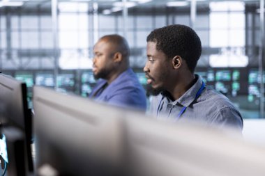 Veri merkezindeki teknisyenlerden oluşan bir ekip, çalışma alanı sistem tanılama testleri ve problemleri çözmek için hata kontrol araçları çalıştırıyor. İş arkadaşları, platformların performansını etkileyen ağ sorunları arıyorlar