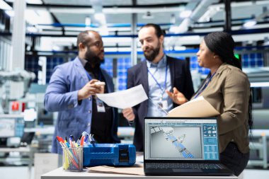 Çok ırklı iş ortaklarından oluşan bir grup bir brifing toplantısında görüşlerini paylaşıyor, güneş paneli üretim sürecini inceliyor. Temiz bir alternatif enerji tesisinde şirket denetimi.