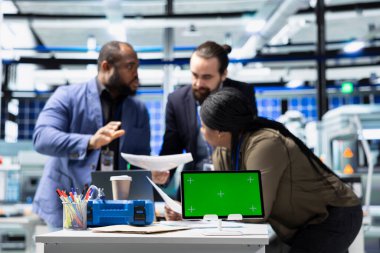 Bir güneş enerjisi santralinde kopyalama alanı ile çalışan çok ırklı teknisyen grubu, sistemleri geliştirme ve teknik gelişim için stratejik planlamayı vurgulama fikirlerini paylaşıyor.