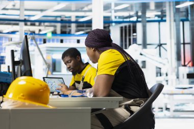 Güneş panelleri imalat fabrikası mühendisi bilgisayar kurulumunda yeni fotovoltaik materyaller ve teknolojiler geliştiriyor. Fabrika teknisyeni ince işçilik için teftiş yapıyor..