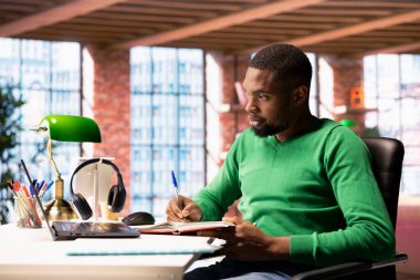 Öğrenci evde internette internette geziniyor, ödev yapıyor, internette bilgi araştırıyor. Dairesinde okul işleri için dizüstü bilgisayarda makaleler okuyan ve not defterine not alan bir adam var.