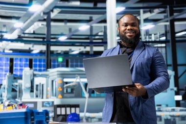 Modern industry expert examines production data in a solar tech facility, ensuring innovation, efficiency and professional oversight to drive renewable energy success. Sustainable solutions.